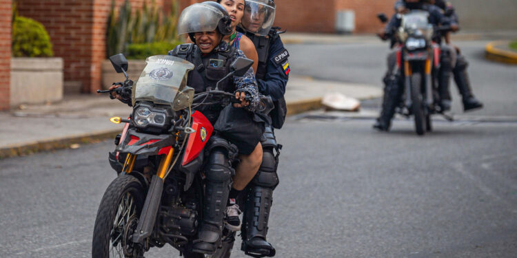 AME6327. CARACAS (VENEZUELA), 29/07/2024.- Integrantes de la Guardia Nacional Bolivariana (GNB) detienen a dos personas durante protestas por los resultados de las elecciones presidenciales este lunes, en Caracas (Venezuela). Miles de ciudadanos han salido para protestar contra los resultados anunciados por el Consejo Nacional Electoral (CNE), que otorga al presidente Maduro el 51,2 % de los votos, un dato cuestionado por la oposición y por buena parte de la comunidad internacional. EFE/ Henry Chirinos