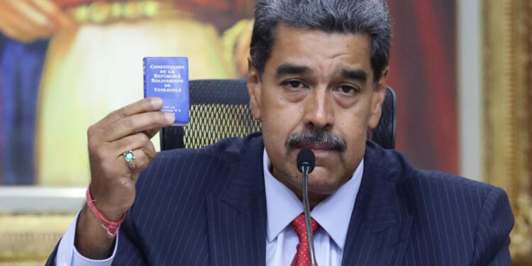 AME6906. CARACAS (VENEZUELA), 31/07/2024.- El presidente de Venezuela, Nicolás Maduro, sostiene la Constitución de la República Bolivariana de Venezuela durante una rueda de prensa este miércoles, en el Palacio de Miraflores en Caracas (Venezuela). Maduro vinculó a Héctor Guerrero Flores -alias 'Niño Guerrero'-, líder de la banda criminal transnacional 'Tren de Aragua', con las protestas desatadas en las últimas horas en contra del resultado electoral del domingo entregado por el Consejo Nacional Electoral (CNE), que lo ratificó como mandatario reelecto. EFE/ Ronald Peña R.