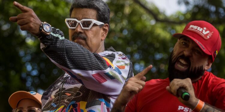 AMDEP3709. CARACAS (VENEZUELA), 16/07/2024.- El presidente de Venezuela y candidato reelección, Nicolás Maduro (i), participa en un acto de campaña este martes, en un sector popular en Caracas (Venezuela). Maduro invitó a sus seguidores a celebrar en el Palacio de Miraflores -sede del Gobierno-, en Caracas, su "triunfo" en las elecciones del 28 de julio, cuando competirá contra nueve opositores por el próximo sexenio en el poder. EFE/ Miguel Gutiérrez
