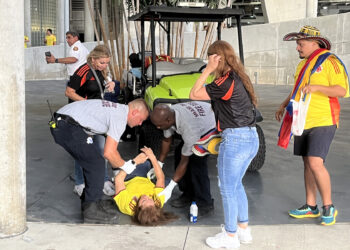 AME1862. MIAMI (ESTADOS UNIDOS), 14/07/2024.- Una mujer es atendida luego de sufrir un desmayo en el estadio Hard Rock previo al partido final entre Argentina y Colombia de la Copa América este domingo, en Miami (Estados Unidos). Una avalancha de decenas de aficionados con camisetas de la selección de Colombia y algunos de Argentina en una de las puertas de ingreso al estadio Hard Rock de Miami obligó a las autoridades a horas del comienzo de la final de la Copa América, a cerrar temporalmente el acceso de todo el escenario.EFE/ David Villafranca