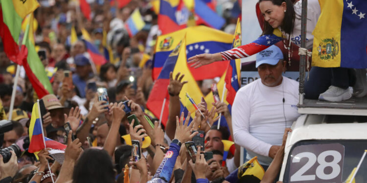 AME4770. CARACAS (VENEZUELA), 25/07/2024.- La líder opositora venezolana, María Corina Machado, saluda a sus simpatizantes durante el cierre de campaña del candidato a la presidencia de Venezuela Edmundo González Urrutia, este jueves, en Caracas (Venezuela). Venezuela celebra este 28 de julio unas elecciones presidenciales consideradas especialmente "decisivas". González Urrutia lidera la principal coalición antichavista -la Plataforma Unitaria Democrática (PUD). EFE/ Ronald Peña R.