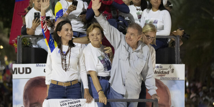 AME4770. CARACAS (VENEZUELA), 25/07/2024.- La líder opositora venezolana, María Corina Machado (i), y el candidato a la presidencia de Venezuela, Edmundo González Urrutia (d), saludan a simpatizantes antes del cierre de campaña de González Urrutia, este jueves, en Caracas (Venezuela). Venezuela celebra este 28 de julio unas elecciones presidenciales consideradas especialmente "decisivas". González Urrutia lidera la principal coalición antichavista -la Plataforma Unitaria Democrática (PUD). EFE/ Ronald Peña R.