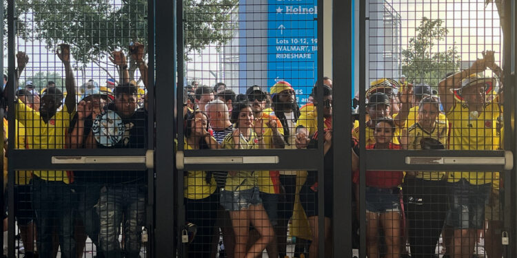 AME1862. MIAMI (ESTADOS UNIDOS), 14/07/2024.- Aficionados esperan a las afueras del estadio Hard Rock este domingo previo a la final de la Copa América en Miami (Estados Unidos). Una avalancha de decenas de aficionados con camisetas de la selección de Colombia y algunos de Argentina en una de las puertas de ingreso al estadio Hard Rock de Miami obligó a las autoridades a horas del comienzo de la final de la Copa América, a cerrar temporalmente el acceso de todo el escenario.EFE/ David Villafranca