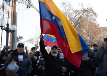 AME5557. SANTIAGO (CHILE), 28/07/2024.- Un ciudadano venezolanos agita una bandera a su llegada a votar en las elecciones presidenciales de Venezuela este domingo, al consulado de Venezuela en Santiago (Chile). EFE/ Ailen Díaz