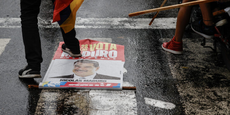 AME6288. CARACAS (VENEZUELA), 29/07/2024.- Una persona pisa un cartel con la imagen del presidente de Venezuela, Nicolás Maduro, durante una protesta por los resultados de las elecciones este lunes, en Caracas (Venezuela). Protestas en Caracas luego de que el Consejo Nacional Electoral (CNE) proclamara a Nicolás Maduro como presidente reelecto de Venezuela, tras los comicios celebrados este 28 de julio. EFE/ Henry Chirinos