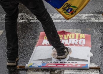 AME6288. CARACAS (VENEZUELA), 29/07/2024.- Una persona pisa un cartel con la imagen del presidente de Venezuela, Nicolás Maduro, durante una protesta por los resultados de las elecciones presidenciales este lunes, en Caracas (Venezuela). Protestas en Caracas luego de que el Consejo Nacional Electoral (CNE) proclamara a Nicolás Maduro como presidente reelecto de Venezuela, tras los comicios celebrados este 28 de julio. EFE/ Henry Chirinos