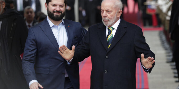 AME8228. SANTIAGO (CHILE), 05/08/2024.- El presidente de Chile, Gabriel Boric (i), y su homólogo de Brasil, Luiz Inácio Lula da Silva, caminan frente a una guardia de honor en el Palacio de La Moneda este lunes, en Santiago (Chile). Lula da Silva realiza una visita de Estado a Chile donde firmará acuerdos bilaterales. EFE/ Elvis González