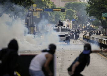 Manifestantes se enfrentan a la policía en las protestas contra los resultados de las elecciones que dieron por ganador a Nicolás Maduro, el día después de las votaciones en Caracas, Venezuela, el lunes 29 de julio de 2024. (AP Foto/Matías Delacroix)