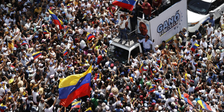 AME1216. CARACAS (VENEZUELA), 17/08/2024.- La líder de la oposición venezolana María Corina Machado (c) agita la bandera de Venezuela frente a seguidores este sábado, en Caracas (Venezuela). Machado reapareció en público para participar en la concentración contra el resultado oficial de las presidenciales que -asegura- ganó el abanderado de la mayor coalición opositora, Edmundo González Urrutia, pese a que el Consejo Nacional Electoral (CNE) otorgó el triunfo a Nicolás Maduro. EFE/ Miguel Gutiérrez