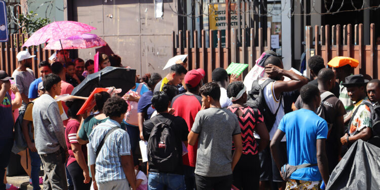 MEX4923. TAPACHULA (MÉXICO), 03/08/2024.- Migrantes hacen fila a la esperar de resolver su situación migratoria este sábado, en la ciudad de Tapachula, en el estado de Chiapas (México). Más de ocho de cada 10 habitantes reportan inseguridad en la principal ciudad de la frontera sur de México, Tapachula, el quinto mayor nivel del país, en medio de la disputa de los carteles del narcotráfico que ha desplazado a cientos de mexicanos hacia Guatemala. Esta es la primera vez en 5 años que Tapachula está entre los cinco municipios más inseguros del país, según la Encuesta Nacional de Seguridad Pública Urbana (Ensu), que la semana pasada reveló que el 84,7 % de sus residentes perciben inseguridad, comparado con el 59,4 % a nivel nacional. EFE/ Juan Manuel Blanco