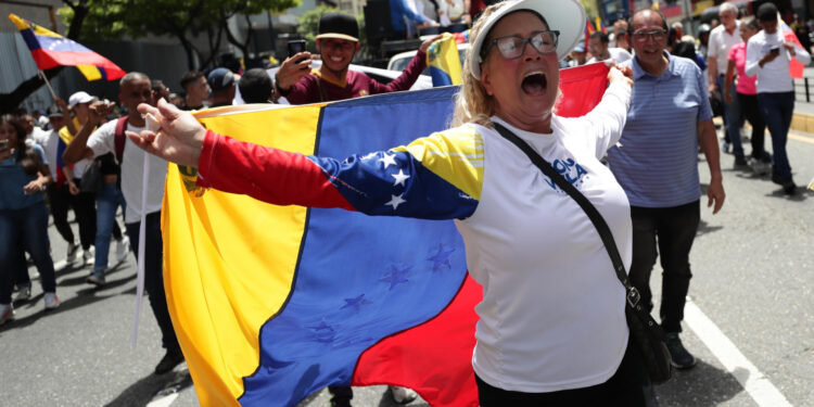 AME3963. CARACAS (VENEZUELA), 28/08/2024.- Una seguidora de la líder opositora venezolana, María Corina Machado, grita consignas en una manifestación este miércoles, en Caracas (Venezuela). Machado aseguró que "ni un solo Gobierno democrático del mundo ha reconocido" la reelección de Nicolás Maduro, cuyo triunfo en las presidenciales del 28 de julio considera un "fraude", igual que buena parte de la comunidad internacional. EFE/ Ronald Peña