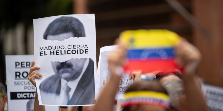 AME8268. CARACAS (VENEZUELA), 11/09/2024.- Un hombre sostiene un cartel con la imagen del presidente de Venezuela, Nicolás Maduro, durante una protesta de familiares de presos políticos en Venezuela exigiendo su libertad este miércoles, en Caracas (Venezuela). EFE/ Ronald Peña R.