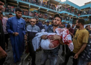 Nuseirat Camp (-), 11/09/2024.- An internally displaced Palestinian father carries the body of his son at a UNRWA-run school, a school-turned-shelter known as al-Jaouni, following an Israeli air strike in Al-Nuseirat refugee camp, central Gaza Strip, 11 September 2024. According to the Palestinian Ministry of Health in Gaza, at least 18 Palestinians have been killed and dozens injured following Israeli air strikes. The Israeli military stated that it conducted a 'precise strike' on militants operating inside a Hamas command and control center in the area of Nuseirat in central Gaza. More than 40,000 Palestinians and over 1,400 Israelis have been killed, according to the Palestinian Health Ministry and the Israel Defense Forces (IDF), since Hamas militants launched an attack against Israel from the Gaza Strip on 07 October 2023, and the Israeli operations in Gaza and the West Bank which followed it. EFE/EPA/MOHAMMED SABER -- ATTENTION EDITORS: GRAPHIC CONTENT