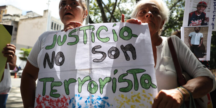 AME2824. CARACAS (VENEZUELA), 26/09/2024.- Familiares de adolescentes detenidos durante las protestas contra los resultados de elecciones presidenciales en Venezuela sostienen carteles este jueves, en una manifestación reclamando su libertad, en Caracas (Venezuela). Un grupo de familiares de detenidos en Venezuela pidió a la Fiscalía que revise los casos de ocho menores de edad apresados en el contexto de las protestas poselectorales, ya que, según sus allegados, "son inocentes" y "están siendo injustamente criminalizados". EFE/ Miguel Gutiérrez