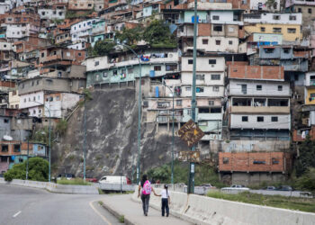 AME8513. CARACAS (VENEZUELA), 18/10/2024.- Fotografía del 10 de octubre de 2024 de una mujer junto a una niña vestida con uniforme escolar, en Caracas (Venezuela). La educación pública en Venezuela está en "emergencia" debido, entre otras razones, a la escasez de docentes, según el gremio, una situación que el Gobierno intenta resolver con varios programas, entre los que destaca un llamado a jubilados a reincorporarse y varias ofertas que buscan convencer a los maestros que dejaron las aulas por los bajos salarios. EFE/ Miguel Gutierrez