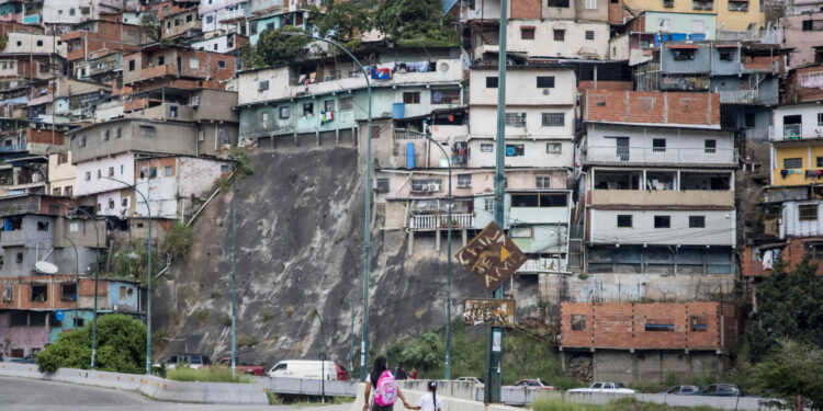 AME8513. CARACAS (VENEZUELA), 18/10/2024.- Fotografía del 10 de octubre de 2024 de una mujer junto a una niña vestida con uniforme escolar, en Caracas (Venezuela). La educación pública en Venezuela está en "emergencia" debido, entre otras razones, a la escasez de docentes, según el gremio, una situación que el Gobierno intenta resolver con varios programas, entre los que destaca un llamado a jubilados a reincorporarse y varias ofertas que buscan convencer a los maestros que dejaron las aulas por los bajos salarios. EFE/ Miguel Gutierrez