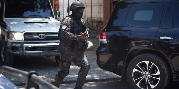 AME3933. PUERTO PRÍNCIPE (HAITÍ), 01/10/2024.- Un agente de seguridad vigila la llegada del primer ministro de Haití, Garry Conille, al liceo Jeunes Filles este martes durante el inicio del año escolar, en Puerto Príncipe (Haití). Comienza el curso académico en Haití, con muchas escuelas convertidas en centros de refugiados y en medio de la crisis y la violencia. EFE/ Mentor David Lorens