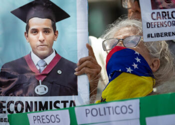 AME9454. CARACAS (VENEZUELA), 21/10/2024.- Una mujer sostiene un cartel durante una manifestación frente a la sede de la ONU, este lunes, en Caracas (Venezuela). Familiares de menores de edad detenidos en el contexto de las protestas desatadas tras las presidenciales del 28 de julio en Venezuela entregaron este lunes un documento a Unicef en Caracas, en el que piden a la agencia de la ONU que interceda para que sean liberados los 70 niños y adolescentes que -aseguran- permanecen encarcelados, así como para verificar en qué condiciones se encuentran. EFE/ Ronald Peña R.