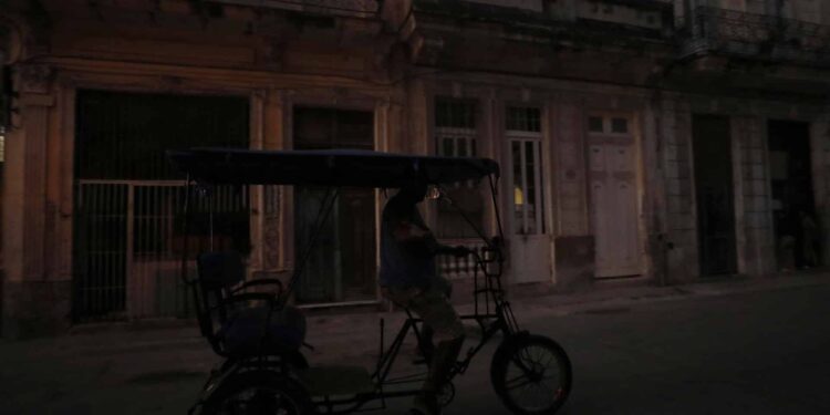 Fotografía de archivo de un bicitaxi que transita por una calle poco iluminada el 26 de marzo de 2024, en La Habana (Cuba). EFE/Yander Zamora