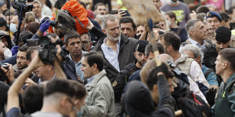 PAIPORTA (VALENCIA), 03/11/2024.- El rey Felipe, durante su visita a Paiporta este domingo. Gritos de 'fuera', así como lanzamiento de barro, están recibiendo a la comitiva de los reyes de España, el presidente del Gobierno, Pedro Sánchez, y el president de la Generalitat, Carlos Mazón, a su llegada al centro de Paiporta. Numerosas personas indignadas han recibido con insultos a la comitiva y se han encarado con ella, mientras que tanto el rey como la reina ha intentado mediar con jóvenes que se les han acercado.EFE/ Biel Aliño