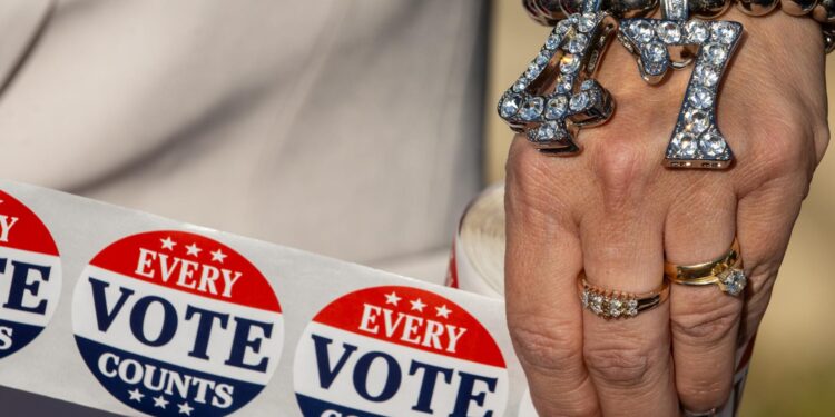 Philadelphia (United States), 05/11/2024.- A Trump supporter wearing a "47" wrist bracelet holds "Every Vote Counts" stickers outside a polling station on Election Day in Philadelphia, Pennsylvania, 05 November 2024. Voters across the country are participating in the 2024 U.S. presidential election, deciding in a closely contested race between Republican candidate Donald J. Trump and Democratic candidate, U.S. Vice President Kamala Harris. Philadelphians are also voting in key Senate and Congressional races on Election Day. (Elecciones, Filadelfia) EFE/EPA/DAVID MUSE