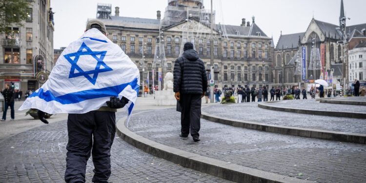 Amsterdam (Netherlands), 08/11/2024.- A man wearing an Israeli flag on his shoulders walks around Dam Square in Amsterdam, Netherlands, 08 November 2024. The Israeli army confirmed on 08 November it was preparing to "deploy a rescue mission with the coordination of the Dutch government ¡...Ç following severe and violent incidents against Israelis in Amsterdam", after clashes broke out after a match between Ajax and Israeli soccer club Maccabi Tel Aviv. (Países Bajos; Holanda) EFE/EPA/Remko de Waal