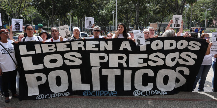 AME9789. CARACAS (VENEZUELA), 21/11/2024.- Familiares de detenidos sostienen una pancarta este jueves, afuera de la sede del Ministerio Público en Caracas (Venezuela). Decenas de personas en Venezuela protestaron este jueves frente a la Fiscalía General para exigir que se produzcan nuevas liberaciones de quienes fueron detenidos tras las presidenciales del 28 de julio, luego de que en los últimos días la Justicia dictase 225 medidas cautelares a favor de algunos de ellos. EFE/ Miguel Gutierrez