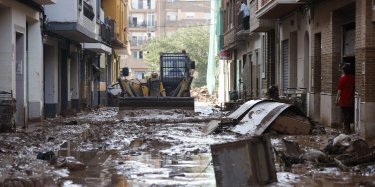 CATARROJA (VALENCIA), 31/10/2024.- Una máquina escavadora retira el lodo acumulado en las calles tras las intensas lluvias caídas por la fuerte dana, este jueves en Catarroja. Catarroja, una de las localidades afectadas por la dana que asoló este martes la provincia de Valencia, se afana por restablecer los suministros cortados a consecuencia del temporal y en ofrecer ayuda humanitaria a los vecinos.EFE/Manuel Bruque