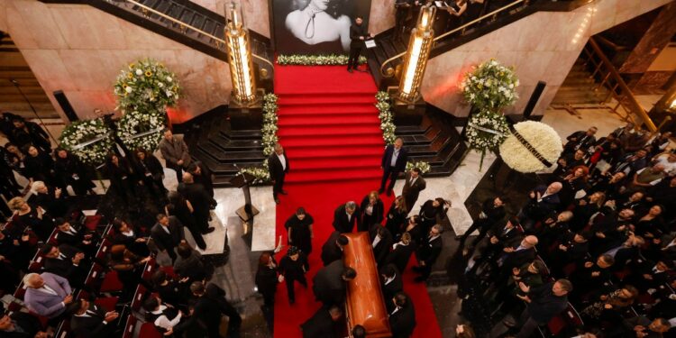 Relatives gather near the coffin of Mexican actress Silvia Pinal at the Bellas Artes Palace, in Mexico City on November 30, 2024. - Pinal, considered the last Mexican cinema diva, muse of Spanish filmmaker Luis Bunuel and star of television and theater, died on November 28, at the age of 93, Mexico's Ministry of Culture reported. (Photo by Rodrigo Oropeza / AFP)