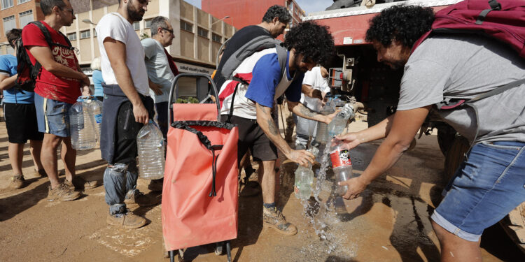 PAIPORTA (VALENCIA), 31/10/2024.- Vecinos de Paiporta recogen agua potable de un camión de la UME, este jueves. La Comunitat Valenciana intenta recuperarse de la peor dana del siglo en España, que ha dejado casi un centenar de muertos en esa región, además de un inmenso escenario de daños en carreteras, calles e infraestructuras de numerosas localidades. EFE/Manuel Bruque