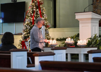 A visitor lights candles during a vigil held at Maranatha Baptist Church, where former President Jimmy Carter used to worship, in Plains, Georgia, on December 30, 2024. - Flags flew at half-staff across the United States on December 30 as global tributes poured in for the life and legacy of Jimmy Carter -- the longest-lived US president, who died aged 100. (Photo by Alex Wroblewski / AFP)