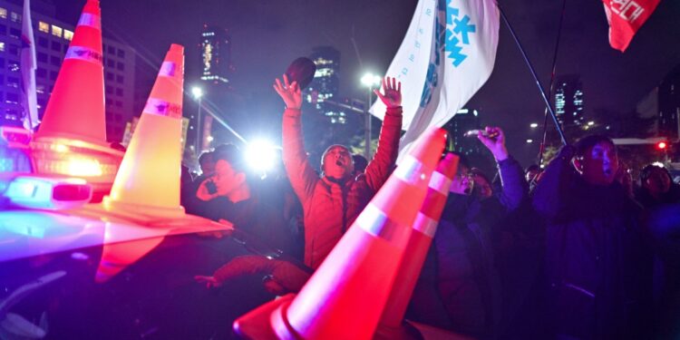 People gather outside the National Assembly in Seoul on December 4, 2024, after South Korea President Yoon Suk Yeol declared martial law. - South Korea's President Yoon Suk Yeol on December 3 declared martial law, accusing the opposition of being "anti-state forces" and saying he was acting to protect the country from "threats" posed by the North. (Photo by Anthony WALLACE / AFP)