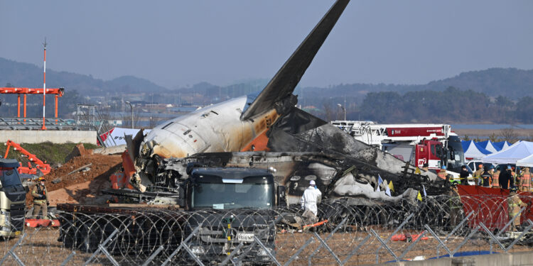 Firefighters and rescue personnel work near the wreckage of a Jeju Air Boeing 737-800 series aircraft after the plane crashed and burst into flames at Muan International Airport in South Jeolla Province, some 288 kilometres southwest of Seoul on December 29, 2024. - A Jeju Air plane carrying 181 people from Bangkok to South Korea crashed on arrival December 29, colliding with a barrier and bursting into flames, with only two survivors rescued so far and 120 confirmed dead. (Photo by JUNG YEON-JE / AFP)