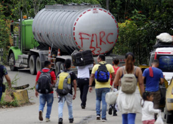 AME1809. BOGOTÁ (COLOMBIA), 21/01/2025.- Fotografía de archivo del 16 de agosto de 2023 de personas caminando junto a un camión con la frase "FARC 33" en la Vereda Santa Rosa, en Catatumbo (Colombia). Los enfrentamientos entre la guerrilla Ejército de Liberación Nacional (ELN) y una disidencia de las FARC en la región colombiana del Catatumbo, con al menos 80 muertos y cerca de 20.000 desplazados, han hecho que el país vuelva a mirar a esa región del noreste que lleva décadas sometida a la violencia de grupos guerrilleros, paramilitares y narcotraficantes. EFE/ Mario Caicedo /ARCHIVO