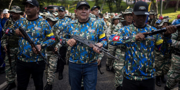 AME9314. CARACAS (VENEZUELA), 07/01/2025.- Integrantes de las milicias bolivarianas participan en un acto de juramentación este martes, en Caracas (Venezuela). El presidente de Venezuela, Nicolás Maduro, activó los "órganos de dirección integral" (Odis) que -aseguró- combinarán el poder político, las Fuerzas Armadas y los cuerpos policiales, con la misión de "defender la paz" del país en los días previos al 10 de enero, cuando insiste en que jurará para un tercer mandato consecutivo. EFE/ Miguel Gutiérrez