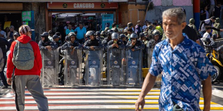 Riot police members stand guard as supporters of Venezuela's President Nicolas Maduro government take part in a demonstration on the eve of the presidential inauguration, in Caracas on January 9, 2025. Venezuela is on tenterhooks facing demonstrations called by both the opposition and government supporters a day before President Nicolas Maduro is due to be sworn in for a third consecutive term and despite multiple countries recognizing opposition rival Edmundo Gonzalez Urrutia as the legitimate president-elect following elections past July. (Photo by Betty Laura Zapata / AFP)