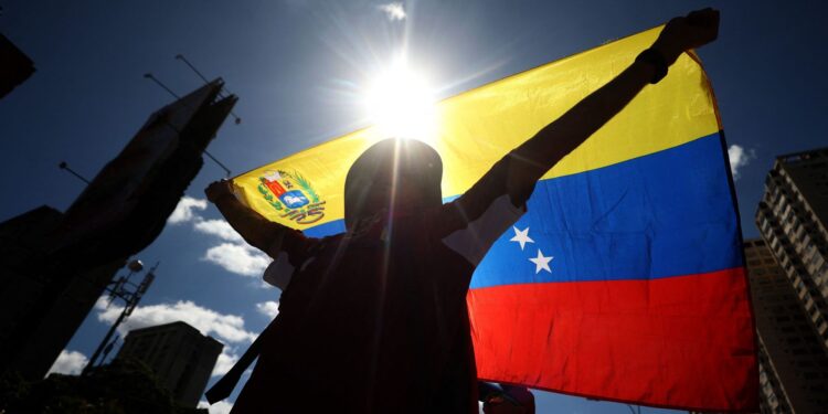 A demonstrator waves a Venezuelan flag during a protest called by the opposition on the eve of the presidential inauguration in Caracas on January 9, 2025. Venezuela is on tenterhooks facing demonstrations called by both the opposition and government supporters a day before President Nicolas Maduro is due to be sworn in for a third consecutive term and despite multiple countries recognizing opposition rival Edmundo Gonzalez Urrutia as the legitimate president-elect following elections past July. (Photo by Pedro MATTEY / AFP)