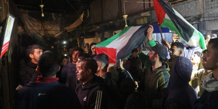 People celebrate along a street at Deir el-Balah in the central Gaza Strip, on January 15, 2025, amid the ongoing war in the Palestinian territory between Israel and Hamas. Crowds of Gazans chanted and embraced on January 15 as news spread that a ceasefire and hostage release deal had been reached between Israel and Hamas aimed at ending more than 15 months of war in the Palestinian territory. (Photo by Eyad BABA / AFP)