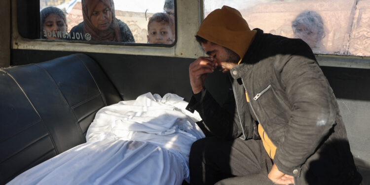 EDITORS NOTE: Graphic content / A Palestinian man mourns a relative, killed in an Israeli strike the previous night, as he sits in the back of an ambulance ahead of the funeral outside the Al-Ahli Arab hospital, also known as the Baptist hospital, in Gaza City on January 1, 2025, as the war between Israel and Hamas militants continues. (Photo by Omar AL-QATTAA / AFP)