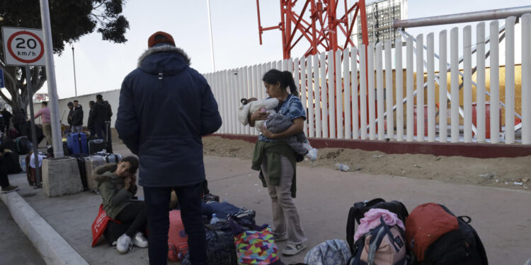 MEX333. TIJUANA (MÉXICO), 20/01/2025.- Migrantes permanecen varados este lunes, en el puerto fronterizo de El Chaparral, en Tijuana (México). Cientos de migrantes quedaron varados después de que el gobierno del nuevo presidente, Donald Trump, cancelara el programa CBP-One, que permitía a migrantes solicitar citas para pedir asilo en EE.UU. a través de los puertos de entrada en la frontera con México. EFE/ Joebeth Terríquez