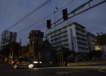 A car navigates through an intersection without stop lights in San Juan, Puerto Rico after a major power outage hit the island on December 31, 2024. - A major power outage plunged much of Puerto Rico into darkness Tuesday, with the US island territory's electric utility saying restoration could take up to two days. The "island-wide blackout" began at 5:30 am (0930 GMT), Luma Energy said in a social media statement. (Photo by Ricardo ARDUENGO / AFP)