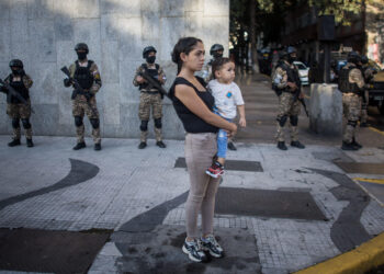 AME8642. CARACAS (VENEZUELA), 04/01/2025.- Una mujer observa un desfile de las "grandes marchas" en respaldo del presidente de Venezuela, Nicolás Maduro, este sábado en Caracas (Venezuela). Autoridades de Venezuela se reunieron este sábado para afinar los preparativos de cara al 10 de enero, cuando Nicolás Maduro afirma que asumirá el nuevo mandato presidencial correspondiente al período 2025-2031 tras una cuestionada reelección que la mayor coalición opositora, Plataforma Unitaria Democrática (PUD), tacha de fraudulenta. EFE/ Miguel Gutiérrez