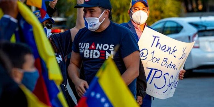 La gente ondea la bandera de Venezuela y carteles de agradecimiento al presidente Joe Biden mientras celebran la aprobación del Estatus de Protección Temporal para más de 300,000 ciudadanos venezolanos que viven en Estados Unidos, en El Arepazo en Doral, Florida, el 9 de marzo de 2021. Daniel A. Varela dvarela@miamiherald.com