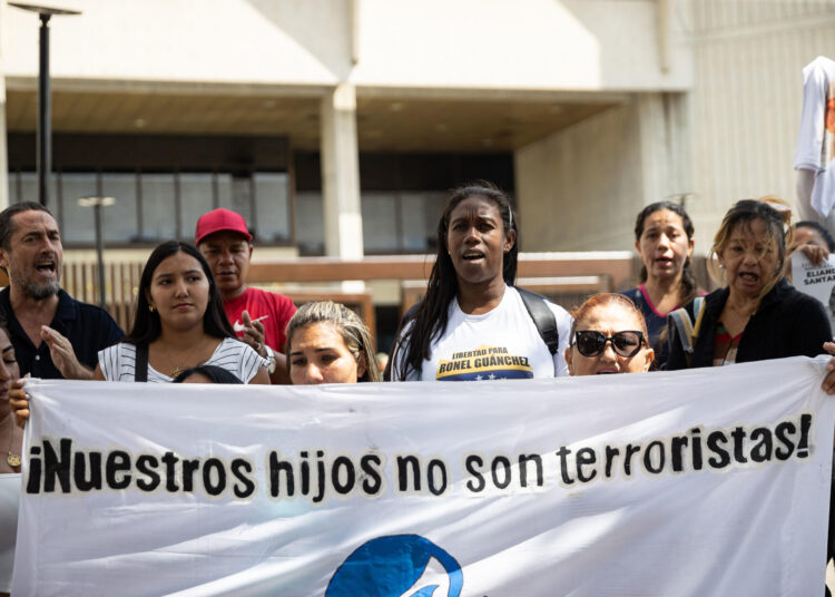 AME1481. CARACAS (VENEZUELA), 19/02/2025.- Personas sostienen carteles durante una protesta este miércoles, al frente del Tribunal Supremo de Justicia de Venezuela, en Caracas (Venezuela). Familiares de detenidos tras los comicios presidenciales de julio de 2024 en Venezuela pidieron en las ciudades de Caracas y Maracaibo (oeste), la liberación "inmediata" y la revisión de los casos de sus allegados, cuya inocencia defienden, mientras la Fiscalía los acusa de "terroristas". EFE/ Ronald Peña