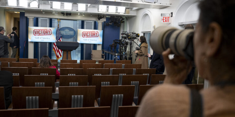 A White House journalists takes a photo of screens displayed in the Brady Briefing Room at the White House in Washington DC, on February 24, 2025. District Judge Trevor McFadden on February 24 declined to immediately order the White House to restore full access to President Donald Trump's events to the Associated Press news agency. McFadden denied the AP's emergency request but set a date next month for a more extensive hearing about the dispute. (Photo by ROBERTO SCHMIDT / AFP)