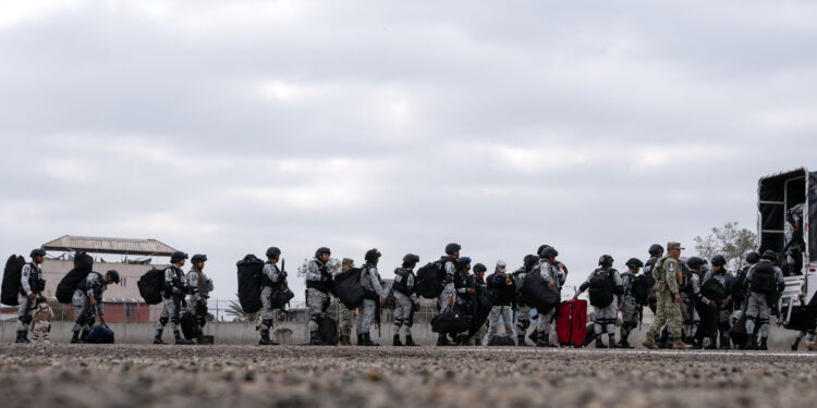 Mexico's National Guard officers arrive at Military Air Base No. 12 in Tijuana International Airport in Tijuana, Baja California state, Mexico, on February 4, 2025. Mexico began the 10,000-strong border troop deployment it had promised US President Donald Trump in exchange for delaying a 25-percent tariff on exported goods, President Claudia Sheinbaum said. (Photo by Guillermo Arias / AFP)