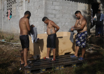 AME3903. MIRAMAR (PANAMÁ), 26/02/2025.- Los venezolanos Jayson Querales (i), Roy Dimarques (c), y José Luis Viloria se bañan este miércoles, en el corregimiento de Miramar en la provincia de Colón (Panamá). EFE/ Bienvenido Velasco