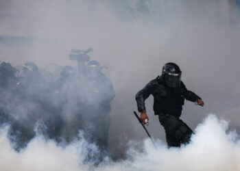 AME8823. BUENOS AIRES (ARGENTINA), 12/03/2025.- Un miembro de la policía argentina enfrenta a manifestantes este miércoles, cerca al Congreso de la Nación en Buenos Aires (Argentina). Hinchas de más de 40 clubes de fútbol y las centrales obreras más grandes de Argentina acompañan a los jubilados en una movilización. EFE/ Juan Ignacio Roncoroni