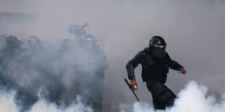 AME8823. BUENOS AIRES (ARGENTINA), 12/03/2025.- Un miembro de la policía argentina enfrenta a manifestantes este miércoles, cerca al Congreso de la Nación en Buenos Aires (Argentina). Hinchas de más de 40 clubes de fútbol y las centrales obreras más grandes de Argentina acompañan a los jubilados en una movilización. EFE/ Juan Ignacio Roncoroni