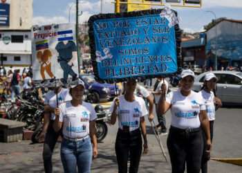 AME1393. CARACAS (VENEZUELA), 21/03/2025.- Personas sostienen carteles durante la recolección de firmas en apoyo a sus compatriotas migrantes deportados desde Estados Unidos a El Salvador este viernes, en Caracas (Venezuela). EFE/ Miguel Gutiérrez